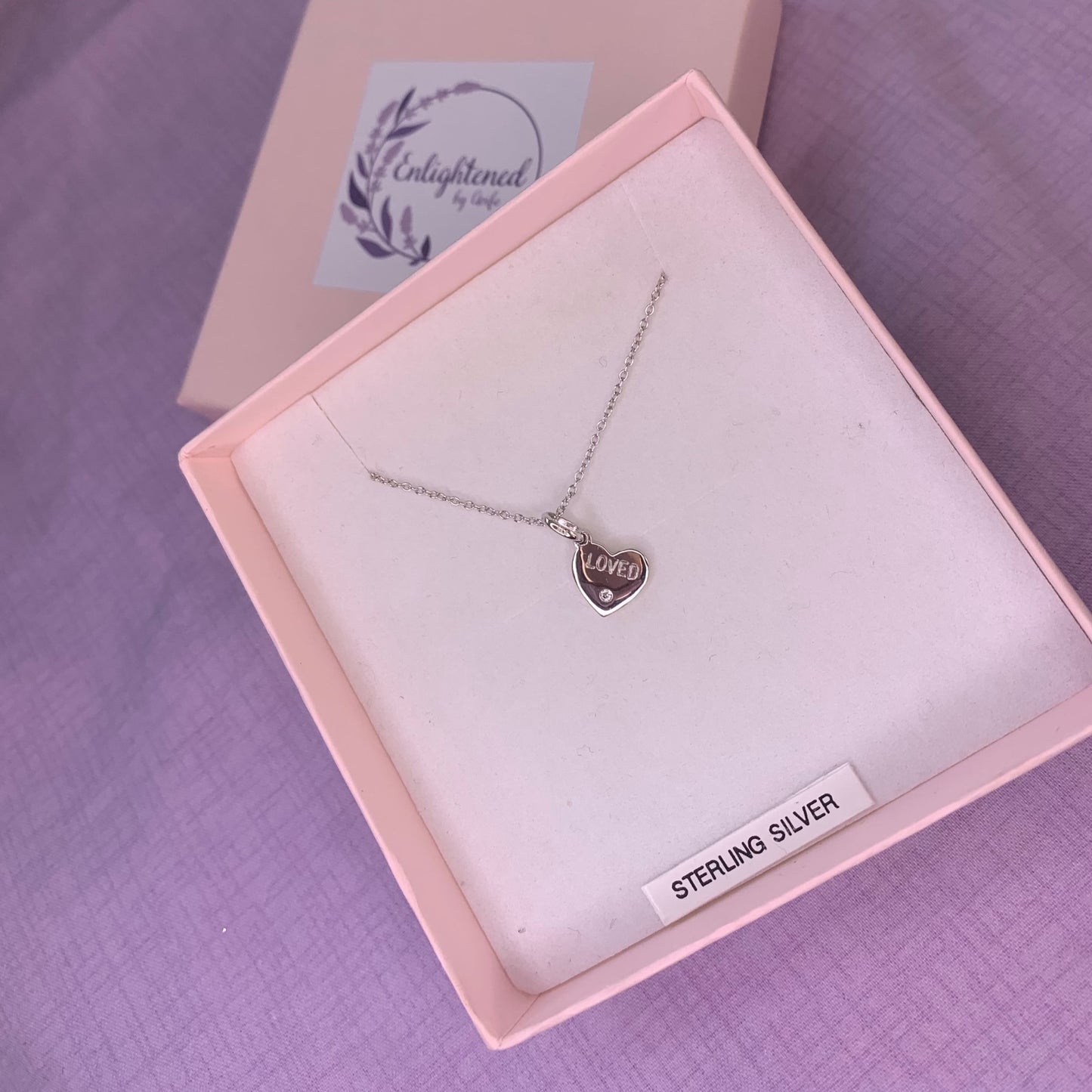 Rhodium plated sterling silver heart pendant with CZ engraved with the affirmation 'loved'. A thoughtful gift, great as a mental health gift or to promote self-love